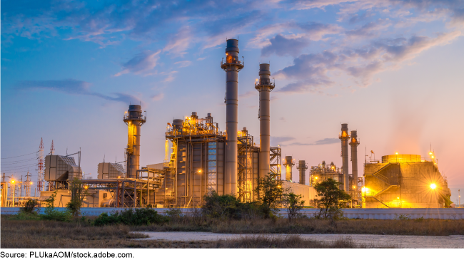 Industrial facility with lights on at dusk.