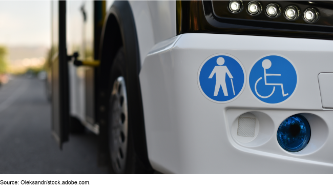 Photo of the front bumper of a mass transportation vehicle, with stickers on it that indicate accommodations for people with mobility issues