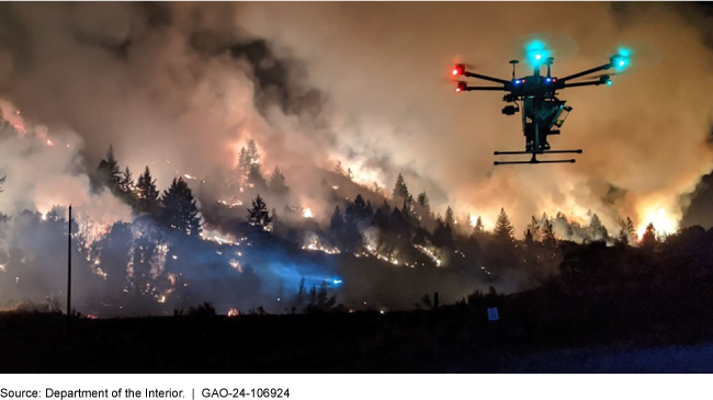 A drone flying over trees on fire.