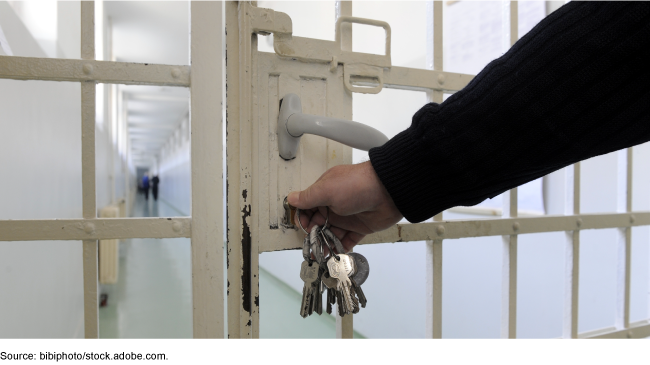 Prison guard opening a cell door