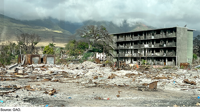 Dark clouds above buildings that have been destroyed and other debris