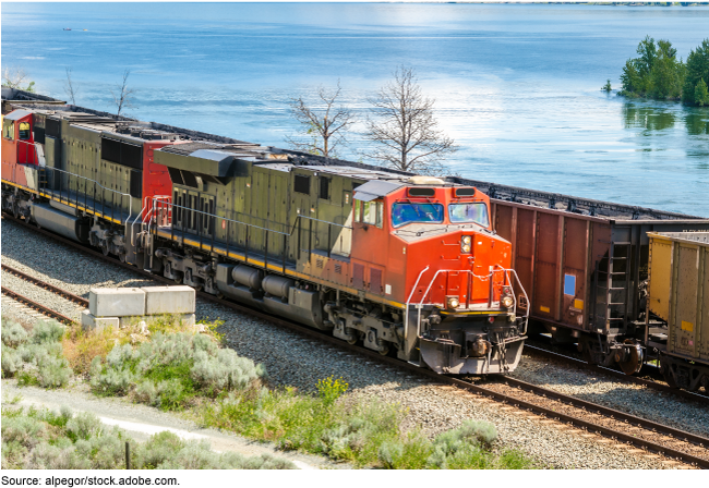 A picture of two trains near a body of water.