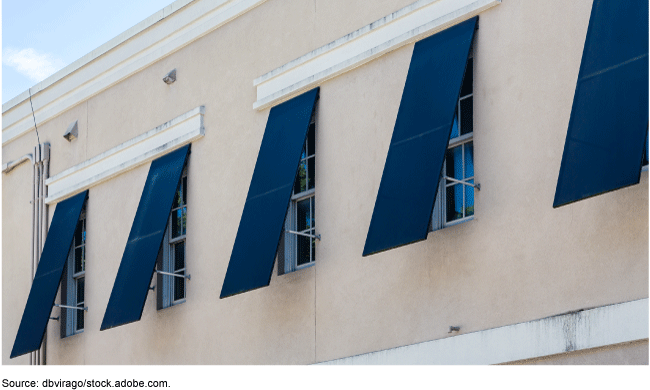 Blue hurricane shutters on building windows