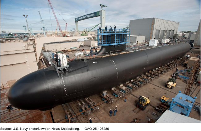 A long, black submarine sitting on a dock.