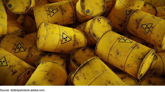 Illustration showing yellow barrels of toxic waste in a pile. 