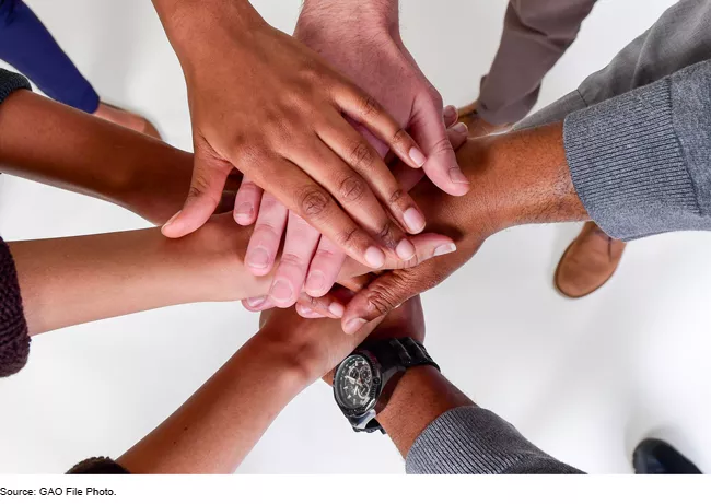 Photo of a huddle of hands representing diverse group