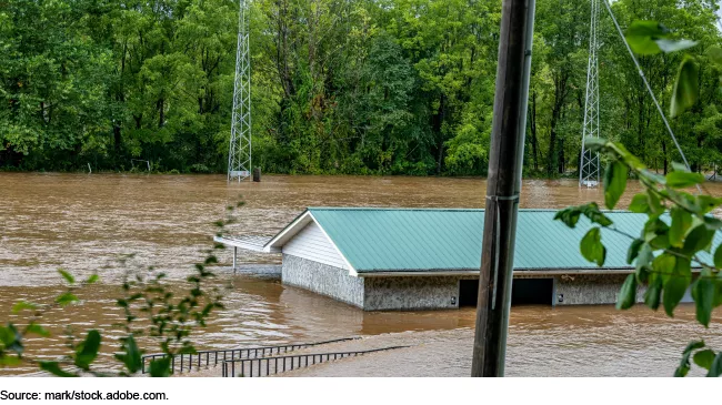 Photo from Hurricane Helene (2024) showing a house or building under water with only its rooftop poking out.