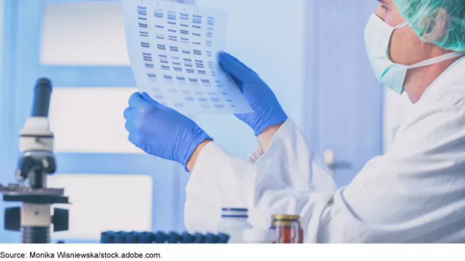 Lab worker holding up a genetic chart