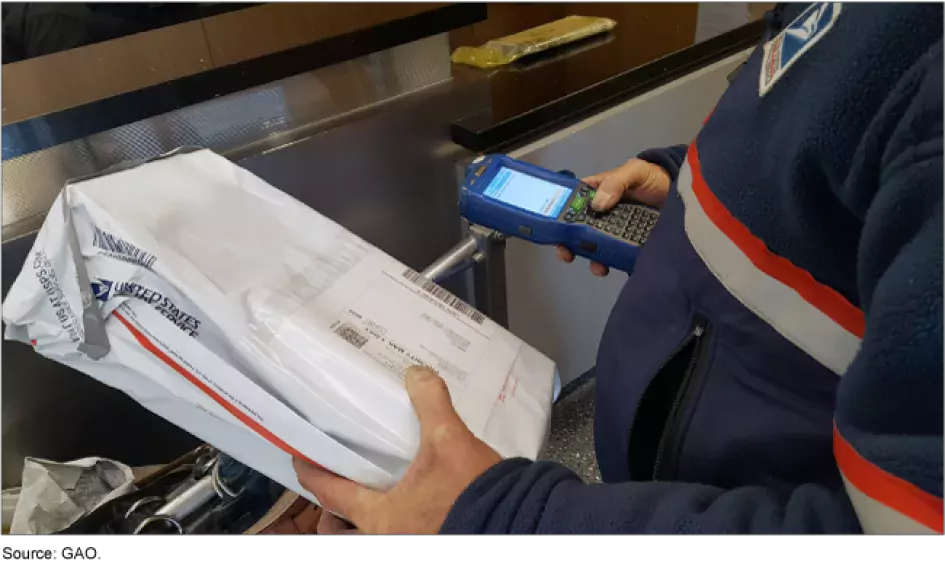 Photo showing a USPS worker processing a package