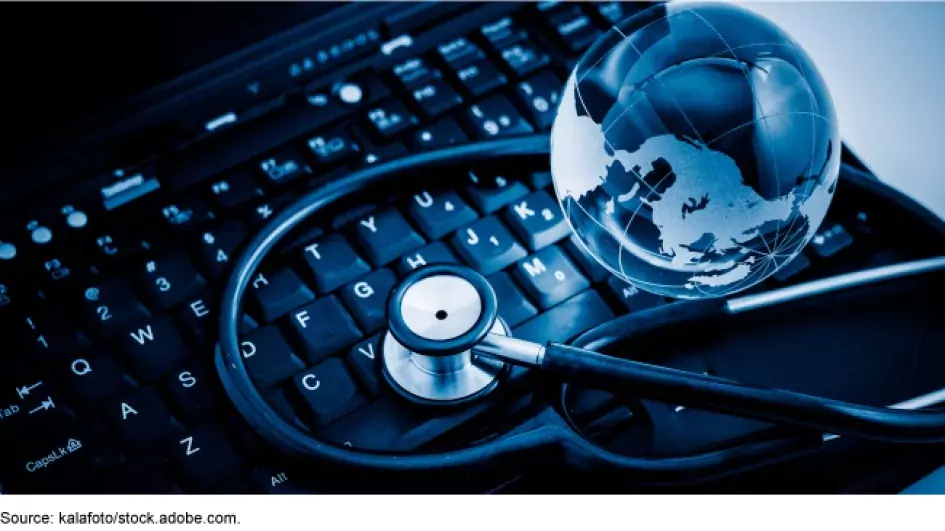 Staged art: A keyboard with a glass globe and stethoscope on it.