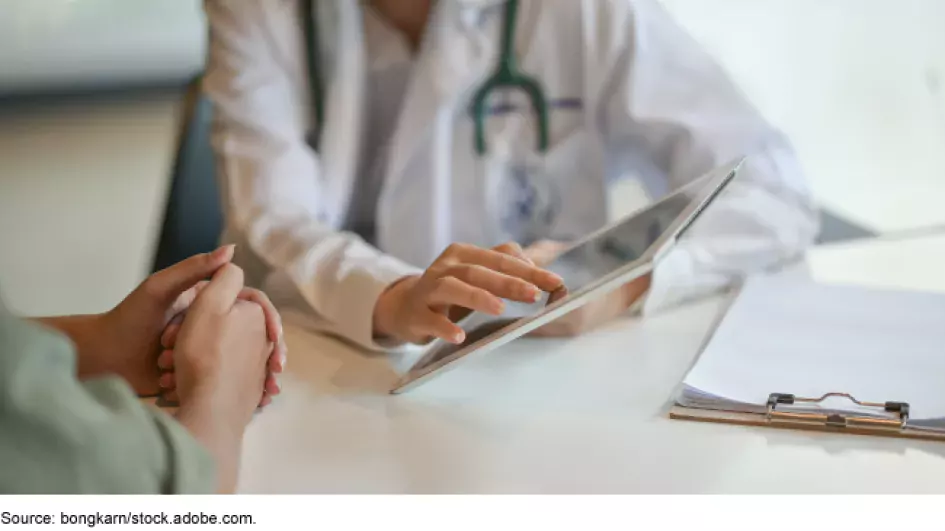 Photo showing a doctor sharing results of a medical screening with a patient.