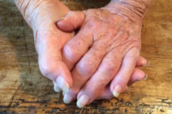 Photo of hands clasped together.