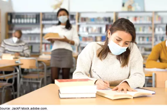 College students in library with masks on.