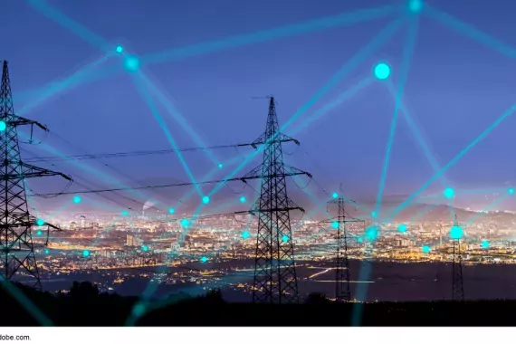 Photo of an electricity grid (the towers) with superimposed lines connecting them in a cyber way.