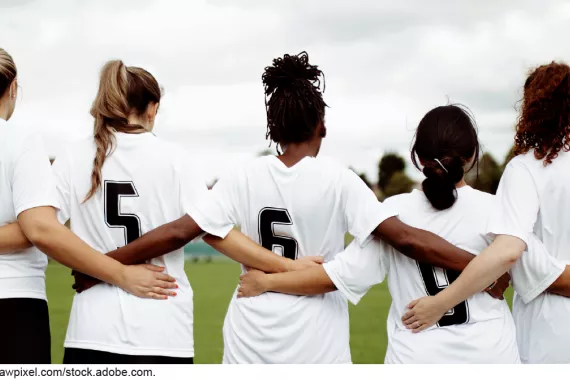 Stock image showing 5 women in soccer jerseys linking arms