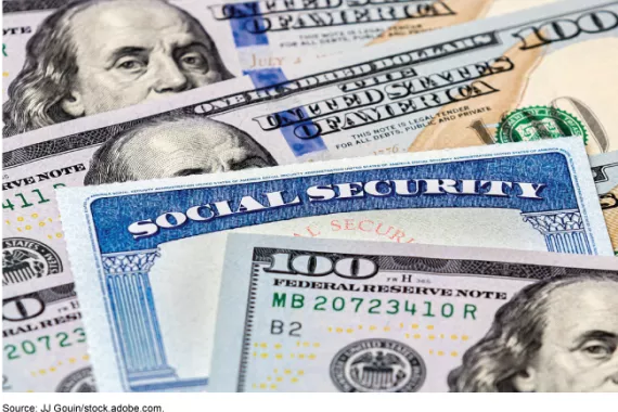 Photo showing a Social Security card lying between $100 dollar bills.